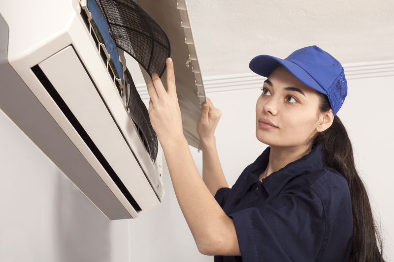 woman technician  repair an air conditioner